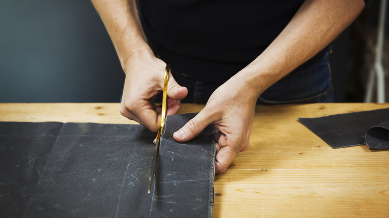 Person cutting fabric with scissors