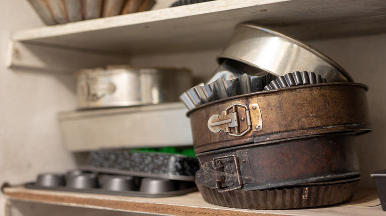unorganized cookware bakeware cabinet