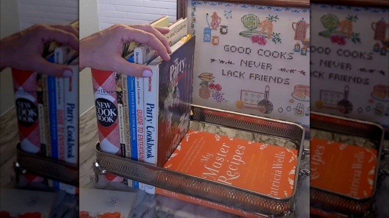 A person puts books into a repurposed casserole holder