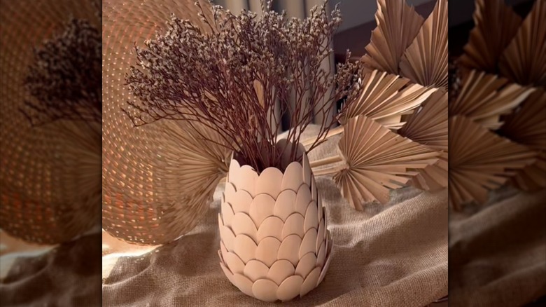 vase made out of a glass mason jar covered in scalloped disposable bamboo wood spoons