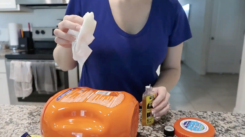 Person removing sticker from laundry pod container