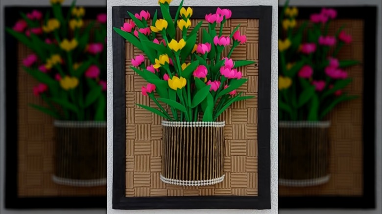 Wall decor DIY with a corrugated cardboard background and faux flowers