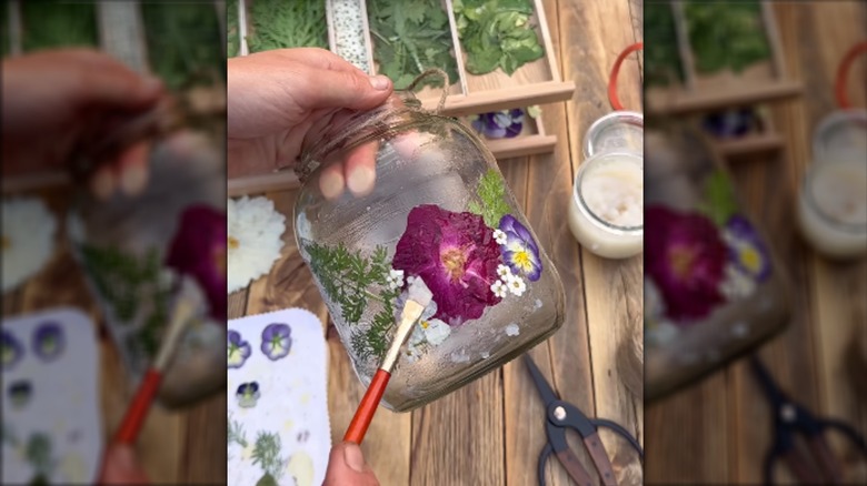 A DIY glass lantern with dried florals and a jute string outside