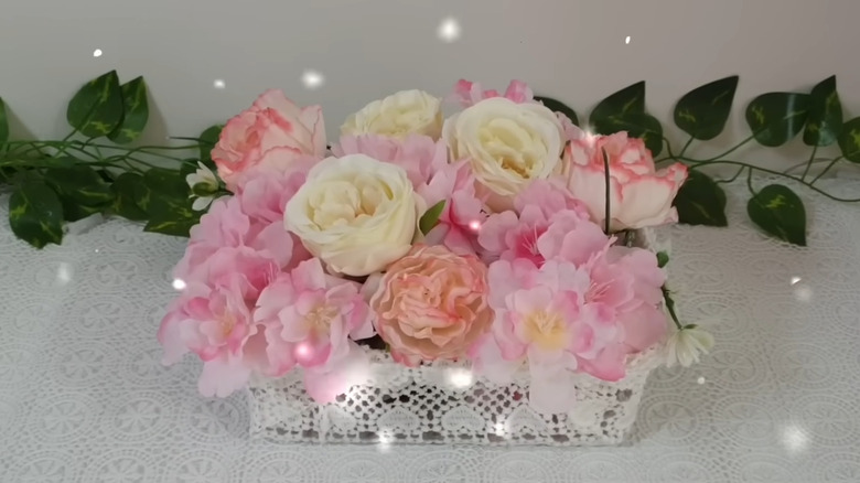 Flower basket made from plastic container and vintage doilies