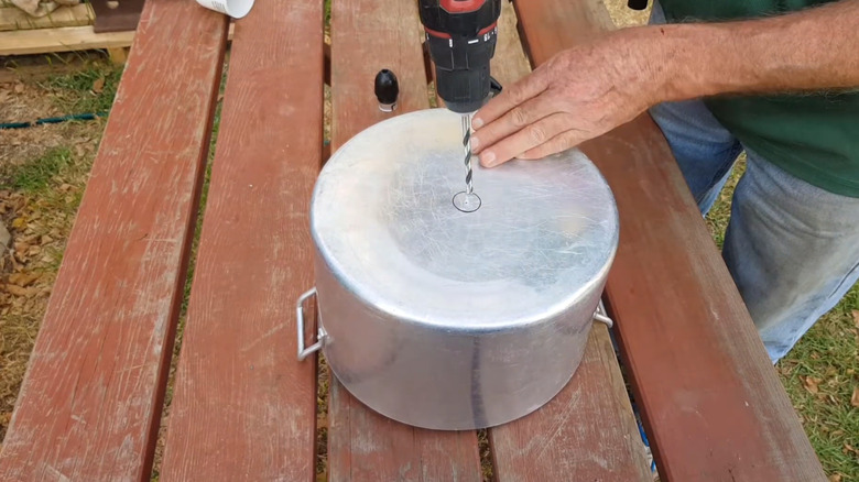 A man drills into a pot