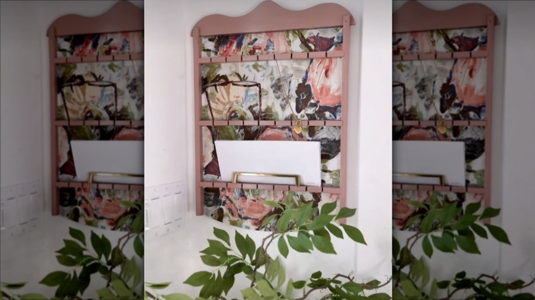 Refinished pink vintage spoon holder with floral wallpaper turned into an entryway organizer