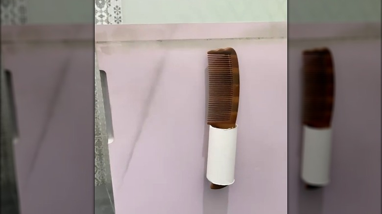 Plain toilet paper tube hanging inside cabinet with comb in it