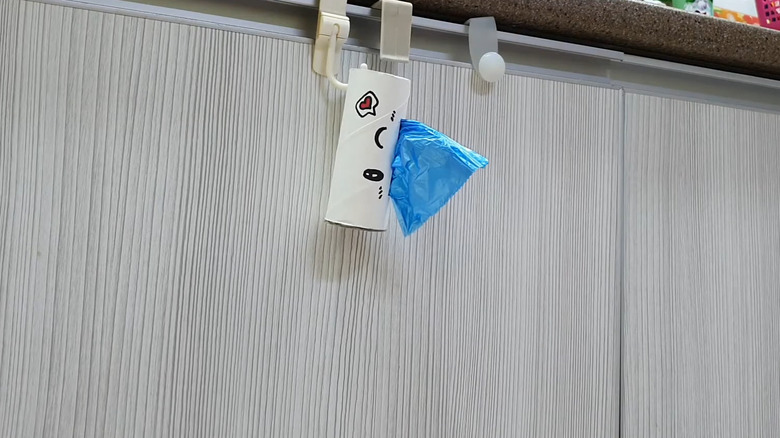 Toilet paper tube with the end of a roll of trash bags sticking out the side