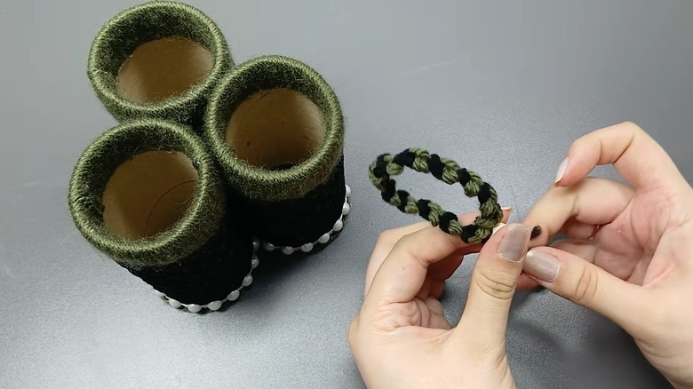 Creator putting the finishing touches on a three-tube holder made from toilet paper tubes