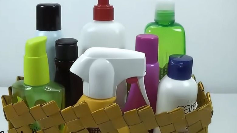 Basket woven from toilet paper tubes with larger bottles in it