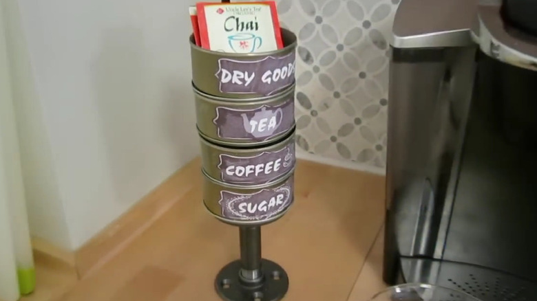 Tuna can tower with labels next to coffee machine