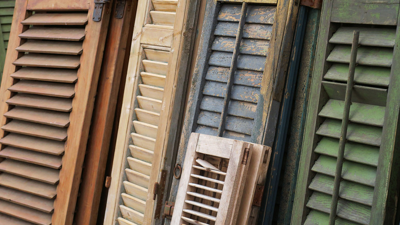 close up of a variety of different colored old window shutters
