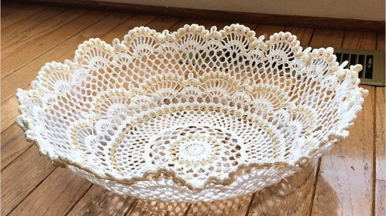 Thrifted doily glued to clear bowl on wood surface