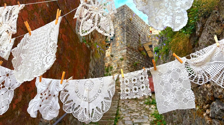 Vintage doilies hanging on a clothesline in a historic town