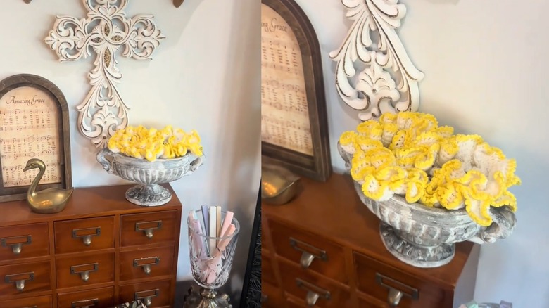 Yellow-rimmed lace doily tucked into antique stone-like vase in vintage room
