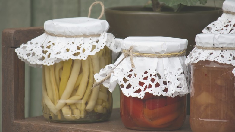 Food jars with white doilies and twine on top