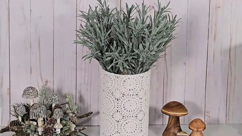 Planter with doilies wrapped around it.