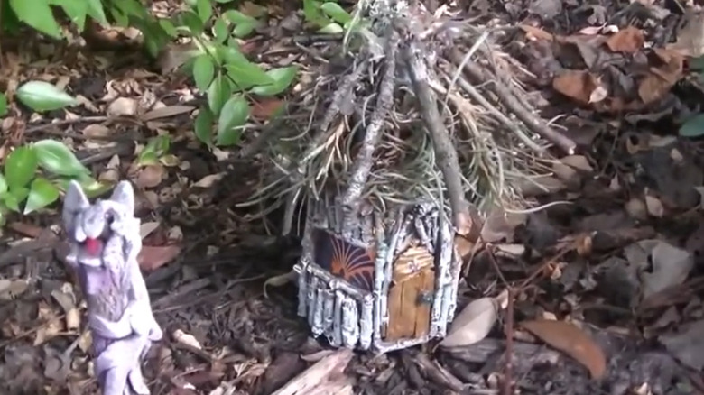 Yogurt jar decorated like a house in a garden