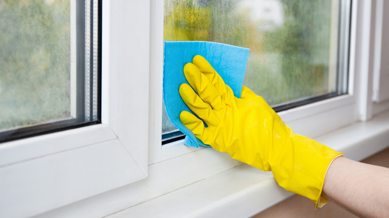 Person cleaning window with microfiber cloth