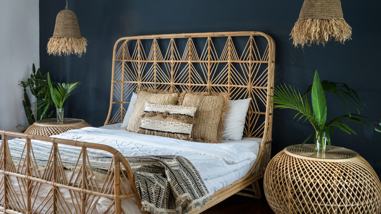 A rattan bed beside woven side tables and light fixtures