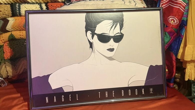 Patrick Nagel print leaning against stack of throws and pillows