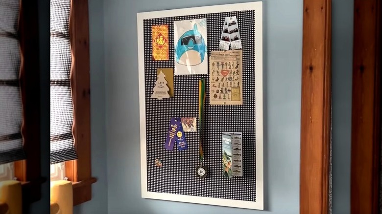 DIY photo board made from reused cardboard hanging on a wall