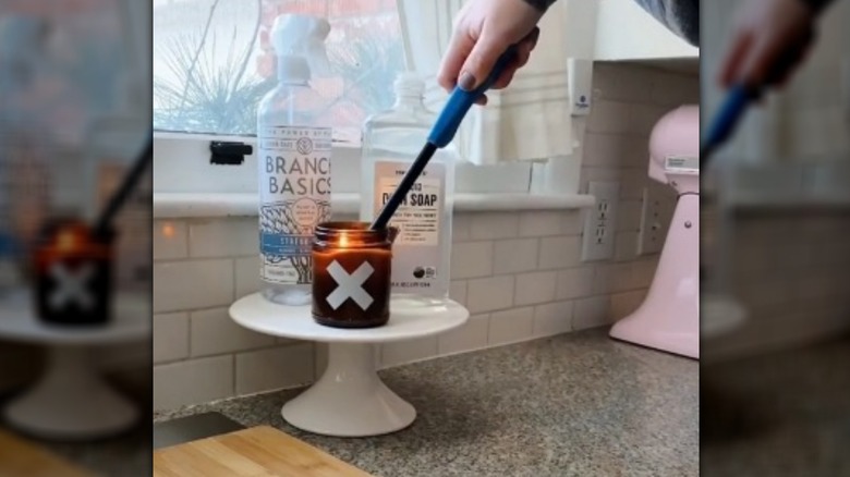 White cake stand with candle being lit