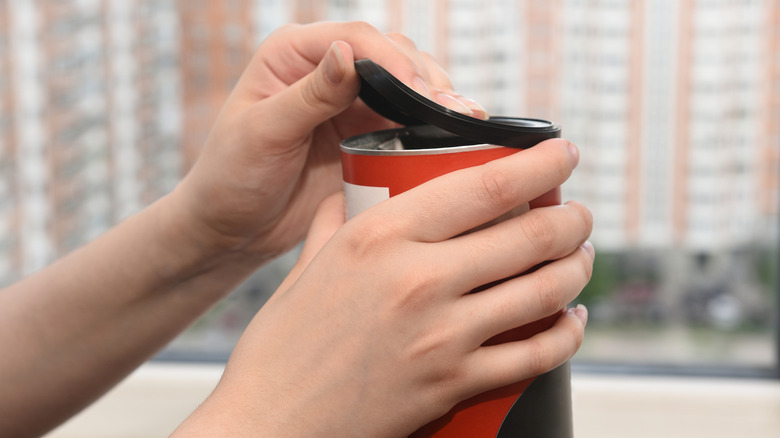 person opening the lid of a food jar