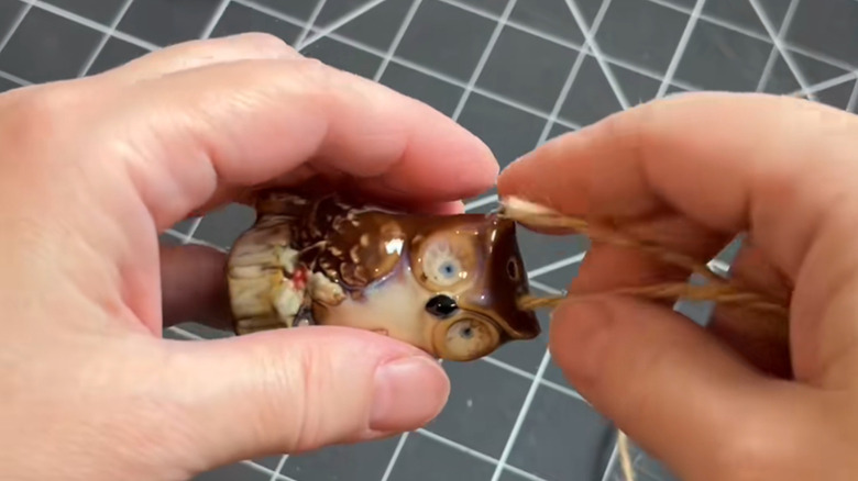 Hands threading yarn through an owl salt shaker