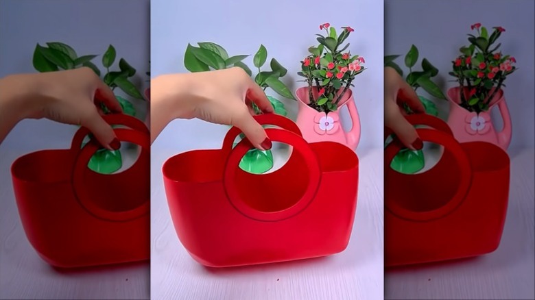 Red detergent bottle cut with a handle to create a storage basket
