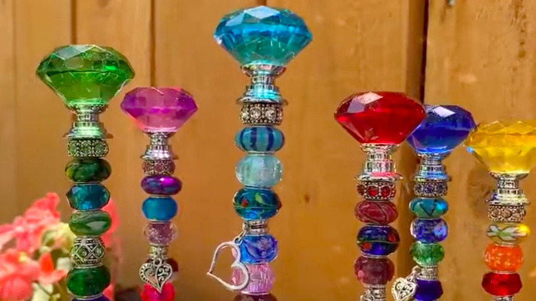 Colorful glass stoppers on top of beaded garden sticks.
