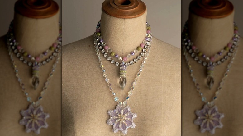 Glass stopper bead necklace on display with pink, green, and purple accent beads.