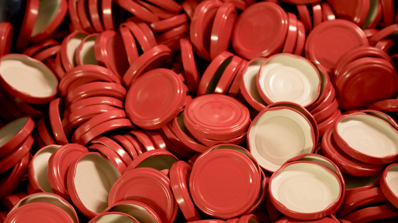 Large pile of red lids from glass jars