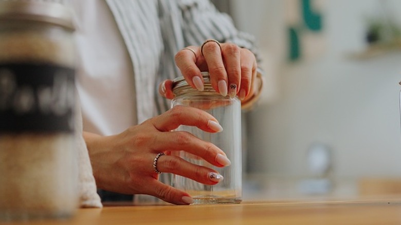 Hands opening a mason jar