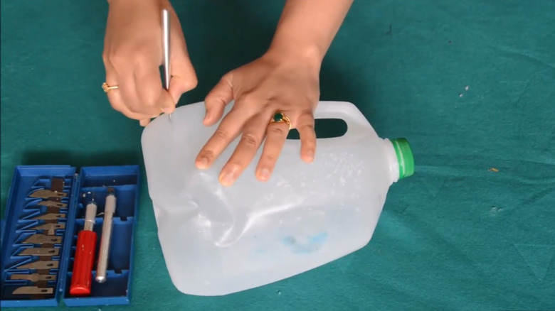 Woman cutting an empty milk jug