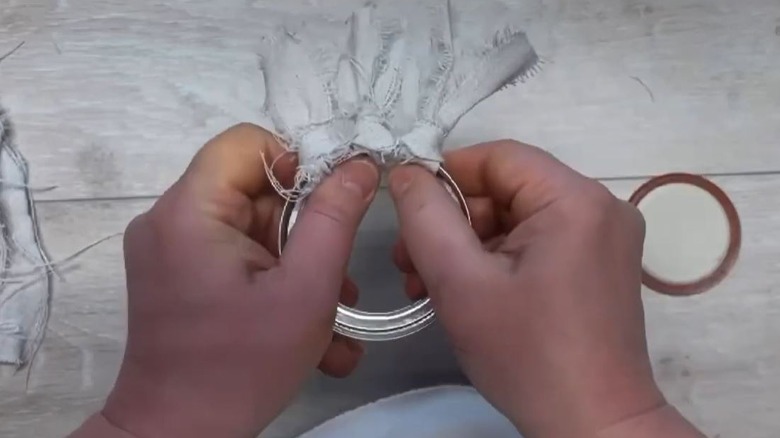 Woman crafting fabric flowers out of Mason jar lids