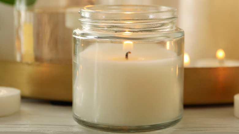 A lit candle in a glass jar