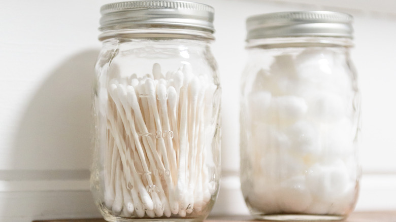 Q-tips and cotton balls inside a glass jar