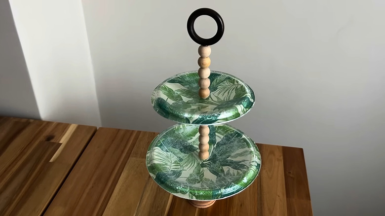 A botanical print tiered tray made of glass pot lids on table