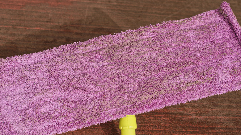 a dirty purple old towel used as a Swiffer mop pad