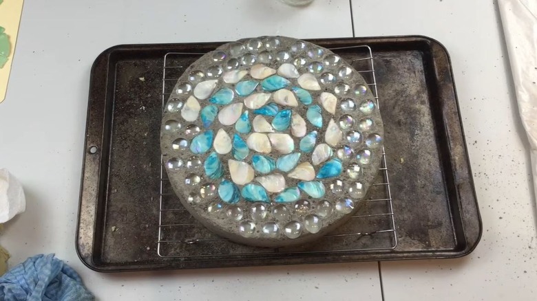 DIY paver made from pie pan mold decorated with beads and shells