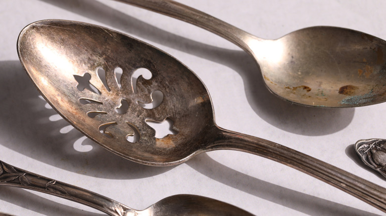 A set of tarnished silver spoons in need of polishing
