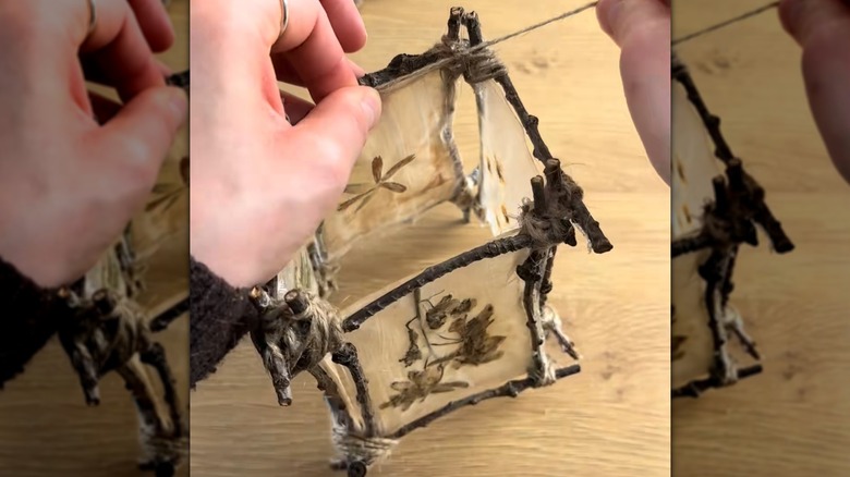Woman making DIY lantern out of used tea bags and twigs