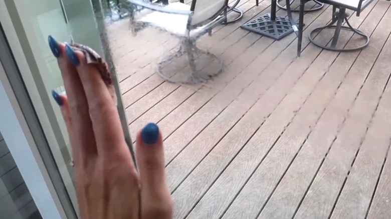 Woman cleaning glass door with tea bag