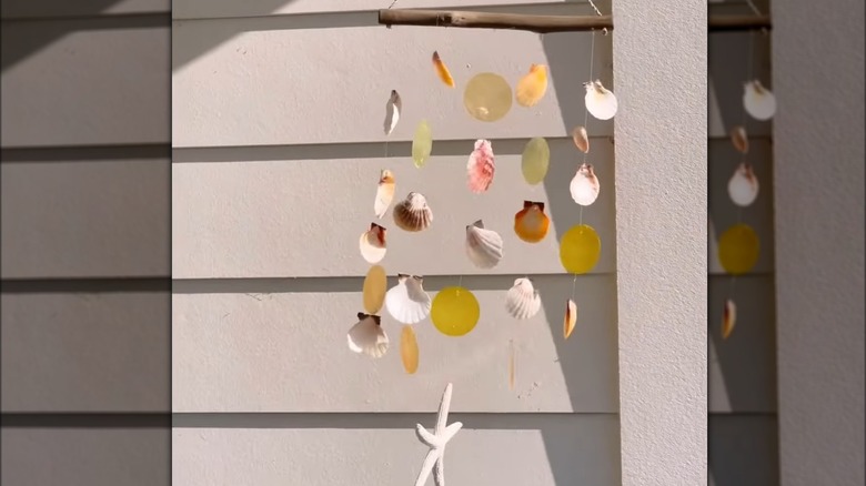 A seashell wind chime hanging on a home's porch