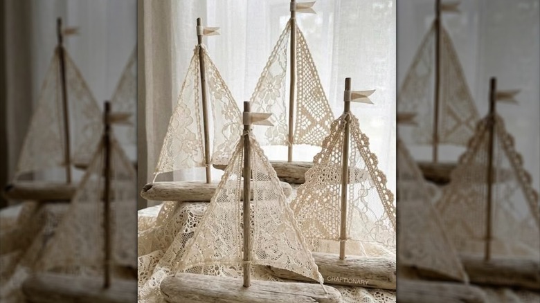 DIY boat decor made from driftwood with vintage doilies as the sails