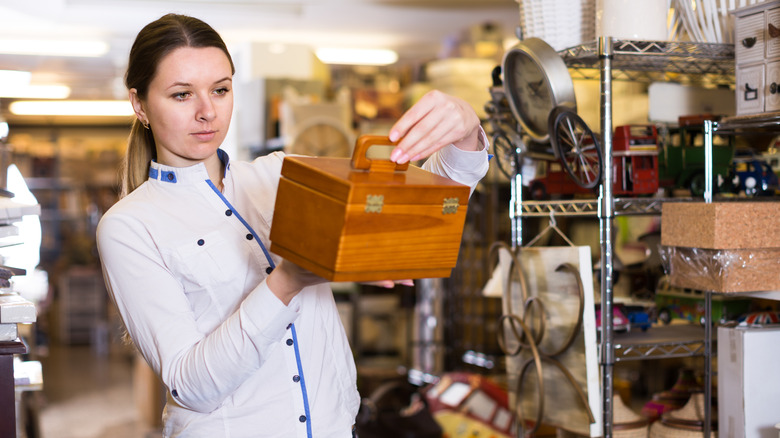 Person looking at small container in an antique store