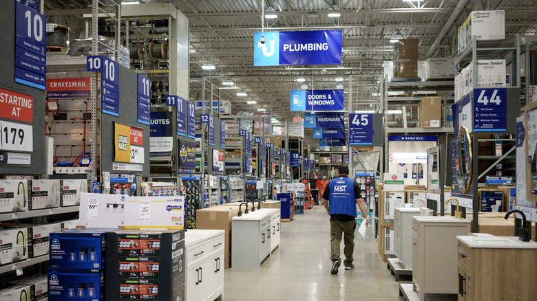 Employee walking along the main aisle of a Lowe's store