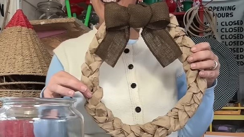 Woman holding DIY wreath made from paper