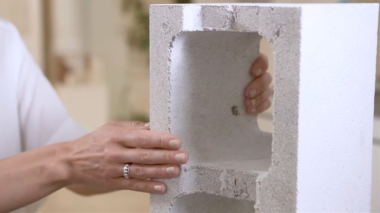 Woman holding an old repurposed concrete block